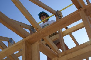 Linda L. holding the tape at the truss peak.