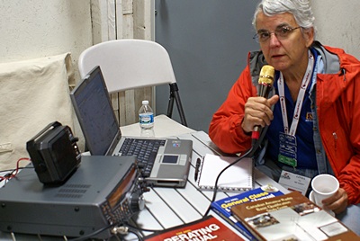 Linda at the SKP Ham BOF "row" table pretending to use the HF rig.  We had a special event call sign (W9E) but not a good location for antennas.