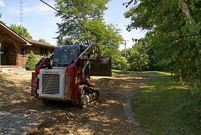 Spreading 21AA road gravel to fix the driveway.