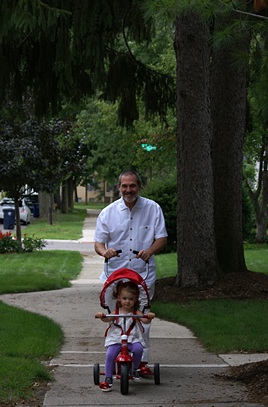It's finally Grandpa Bruce's turn to drive the tricycle.