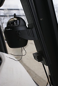 Magnetic compass mounted to the oak board on the center windshield pillar.