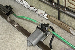 This motor (center) was used to drive two geared pullies via flexible drive shafts (green) to open/close the drawer under the sleeper-sofa. (One of the pullies is visible upper left.)