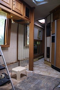 A view from the kitchen of the dinette corner and hallway. A custom desk will go where the dinette seating used to be and double as work surface for the kitchen.