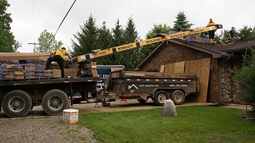 Wimsatt unloads shingles onto the garage roof.