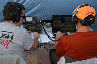 Operating stations are often staffed by two people, one operating the radio (left) and the other logging the contacts (right).