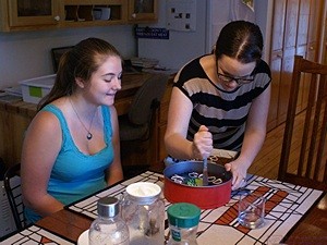 Grand-daughter Katie (L) waiting for a slice of cake baked by her step-mom (our daughter, Meghan, on right).