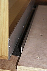 The piece of aluminum angle that will prevent the refrigerator from sliding sideways into the pantry. It is not installed yet as the plywood refrigerator base is not stained yet.