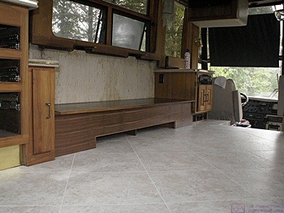 Part of the kitchen and living room floor after being cleaned as viewed from the hallway looking towards the built-in sofa.