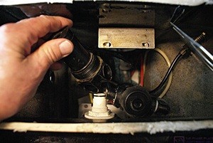 The vacuum breaker (L, in my hand) and the air/water sequence valve (R) as viewed looking straight down into the back of the toilet. The Microphor LF-210 toilet does not have a water tank. The entire back of the toilet is full of valves, air lines, and water lines.