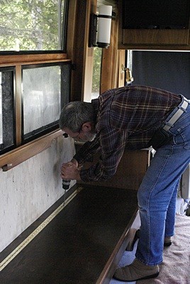 Bruce installs the fixed side of the piano hinge to the top of the wiring chase above the OTR HVAC duct.