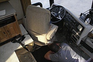 Tyler bolts the new Flexsteel driver’s seat to the existing pedestal swivel base. There is not a lot of room to work around the base of this seat.