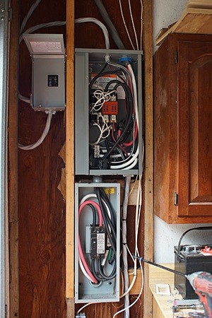 The small box upper left is the new 100 A main disconnect for the electrical panel in the garage. The large box upper right is the automatic transfer switch and the large box below it is the 200 A service entrance disconnect.