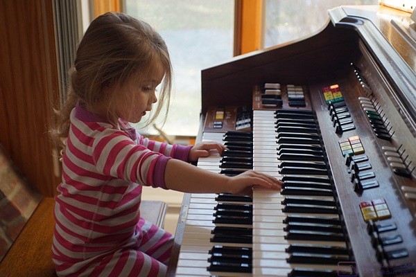 Madeline plays (at) the organ. It is one of her favorite “toys” at our house.